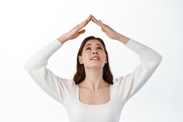 Image of young woman struggling make roof with hands above head, looking troubled and upset at her...