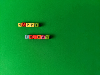 "HAPPY FRIDAY" made of beads cube isolated with green background.