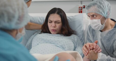 Pregnant young woman pushing to give birth in hospital - Powered by Adobe