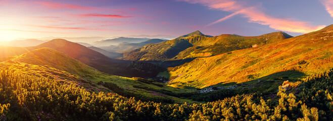 Obraz na płótnie Canvas Panorama landscape of Carpathian mountains during sunset. Scenic image of fantastic atmosferic scenery with picturesque sky, mountain range under vivid sunlit. Amazing nature scenery. creative image