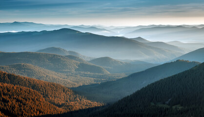 Awesome alpine highland in sunny misty morning. Wonderful Autumn landscape with mountain layers....