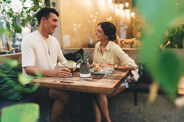 Cheerful young couple having lunch in restaurant and talking
