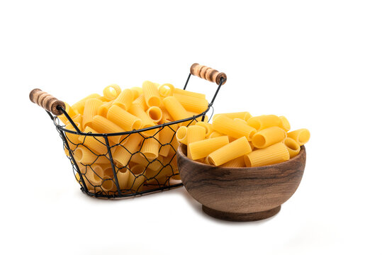 Wooden Bowl And Wicker Basket Of Of Raw Tube Pasta Isolated On White Background