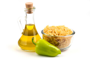 Uncooked pasta, pepper and bottle of oil on white background
