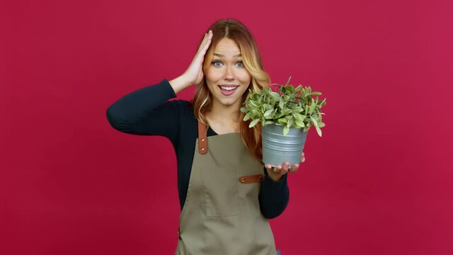 Young blonde girl holding a plant with surprise and shocked facial expression over isolated background