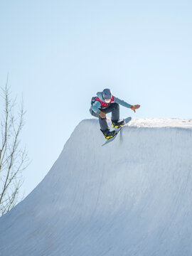 People are enjoying half-pipe skiing / snowboarding	