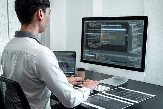 Young Programmer working in software javascript computer in IT office, Writing codes and data code website and coding database technologies to find solution to problem