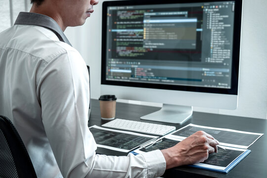 Young Programmer working in software javascript computer in IT office, Writing codes and data code website and coding database technologies to find solution to problem