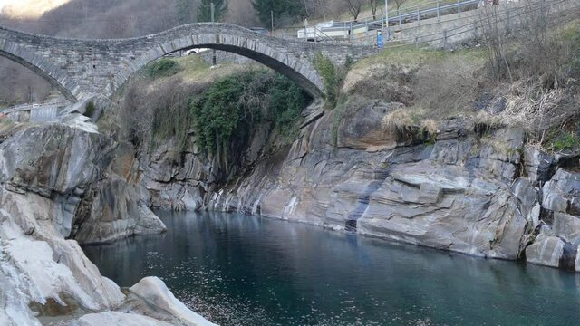 River in Verzasca Valley with green water and zoom in a roman bridge