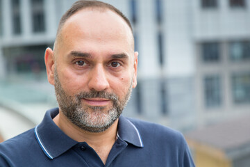 Close-up portrait of a middle-aged business man against the background of the city.