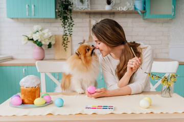 young woman and dog in the kitchen preparing for Easter
