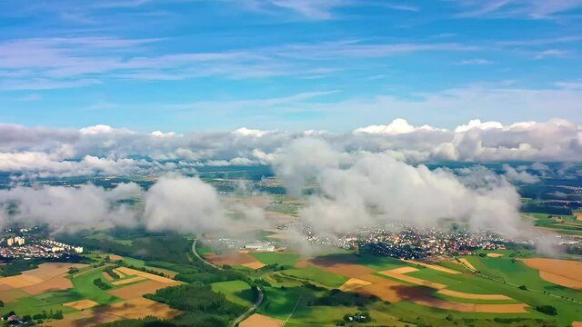 Aerial view of flowing clouds, beautiful towns, and farmland full of vitality