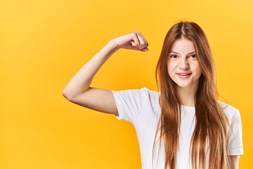 Young Woman Shows Muscles On Arm, Shows Biceps. The Concept Of Strong, Powerful People