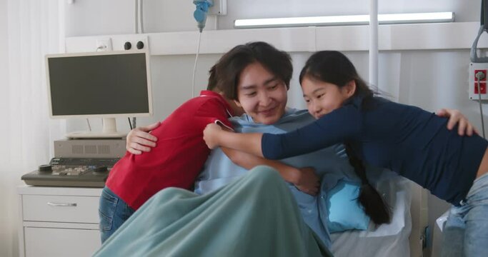 Diverse children visiting adoptive asian father in hospital ward
