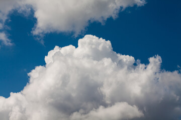Naklejka na ściany i meble A white cloud against an intense blue sky