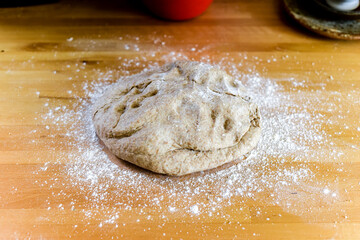 Raw dough and flour ingredients to make a loaf of bread at home