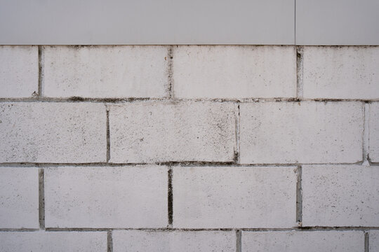 Texture of a concrete block wall painted white. Concrete wall as background or texture. Part of a block wall, for background or texture.