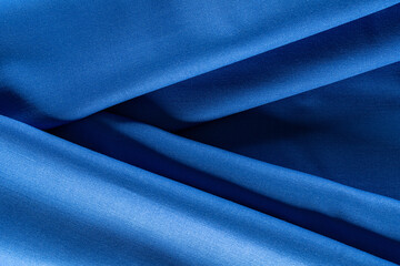 evenly draped fabric of deep blue color for tailoring, background