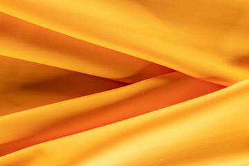 evenly draped fabric of bright orange color for tailoring, background