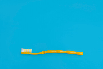 one yellow toothbrush on a blue background copy the space. the concept of oral hygiene, dental care