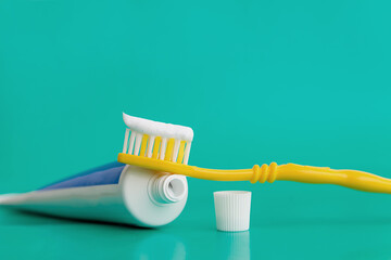 toothpaste smeared on a yellow toothbrush close-up on a blue background copy space. the concept of dental care