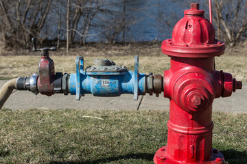 Red fire hydrant with attachment and hose for hydrant flushing