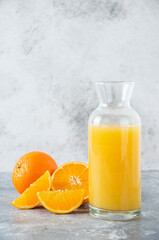 Glass pitcher of juice with slice of orange fruit
