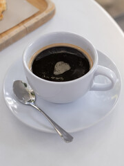 a cup of coffee on white table with work break time, food concept. Close up of a glass of hot espresso mix Soft drink with copy space