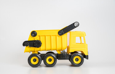 Plastic car. Toy model isolated on a white background. Yellow truck.