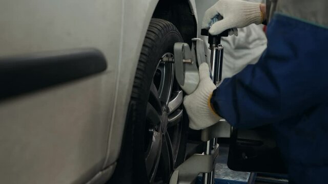 Professional mechanic adjusting automobile wheel alignment car service repair