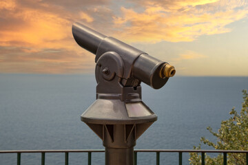 A coin public telescope at sunset. A telescope directed to the blue mediterranean sea, Capri Island, Tyrrhenian sea, Italy