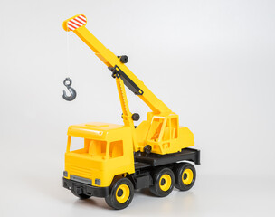 Obraz na płótnie Canvas Plastic car. Toy model isolated on a white background. Yellow truck mounted crane.