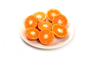 Whole and slice juicy fresh orange fruits in a plate