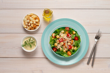 Caesar salad with chiken , on a white wooden table, top view, no people,