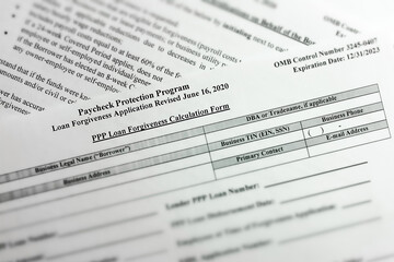 Fototapeta premium selective focus photo of paycheck protection program loan forgiveness application form revised. paycheck protection program new round