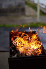 Flame from brazier. BBQ preparation close up