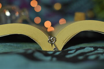Small romantic key standing next to a book