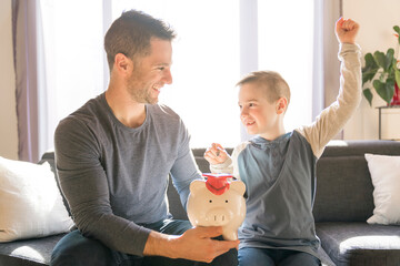 Father with little son with piggy bank at home