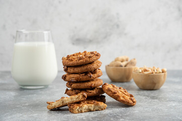 Peanuts, glass of milk and cookies with organic peanuts on marble background