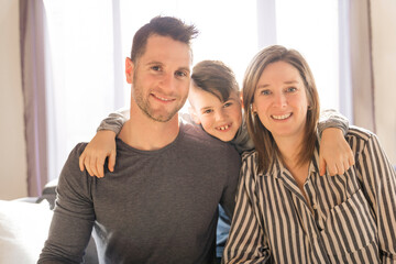 married couple and son sit on the sofa at home