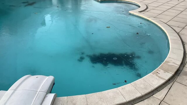 Frozen swimming pool covered in ice and snow near shop