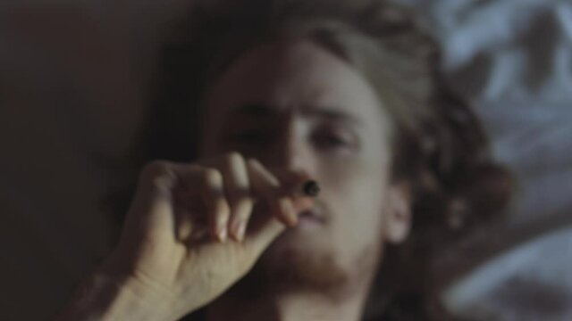 Man Lying Down Smoking a Cannabis Joint
