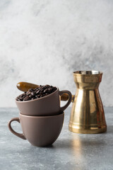 Cup full of coffee beans and coffee maker on marble background