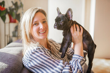 Portrait of happy adult at home with french bulldog
