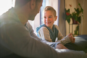 father and son sit on the sofa at home