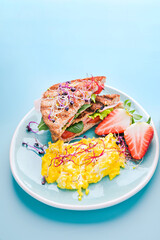Coarse bread toast with ham, salad and scramble, sprinkled with sprouted seeds. Super food. Delicious healthy breakfast on a bright background. High quality photo. Vertical photo