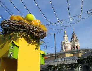 Festive decoration of the city streets for the spring holidays - Nest with eggs and birdhouses.  happy Easter. Near the monastery
