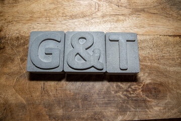 A concrete block saying G and T on a wooden background