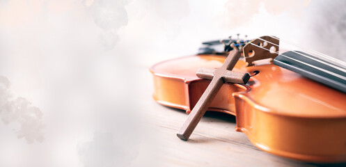 Wooden cross over violin on white old background. selective focus, Copy space.