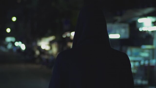 Defocused Streetview of Background and a Suspicious Male Walking in the Streets